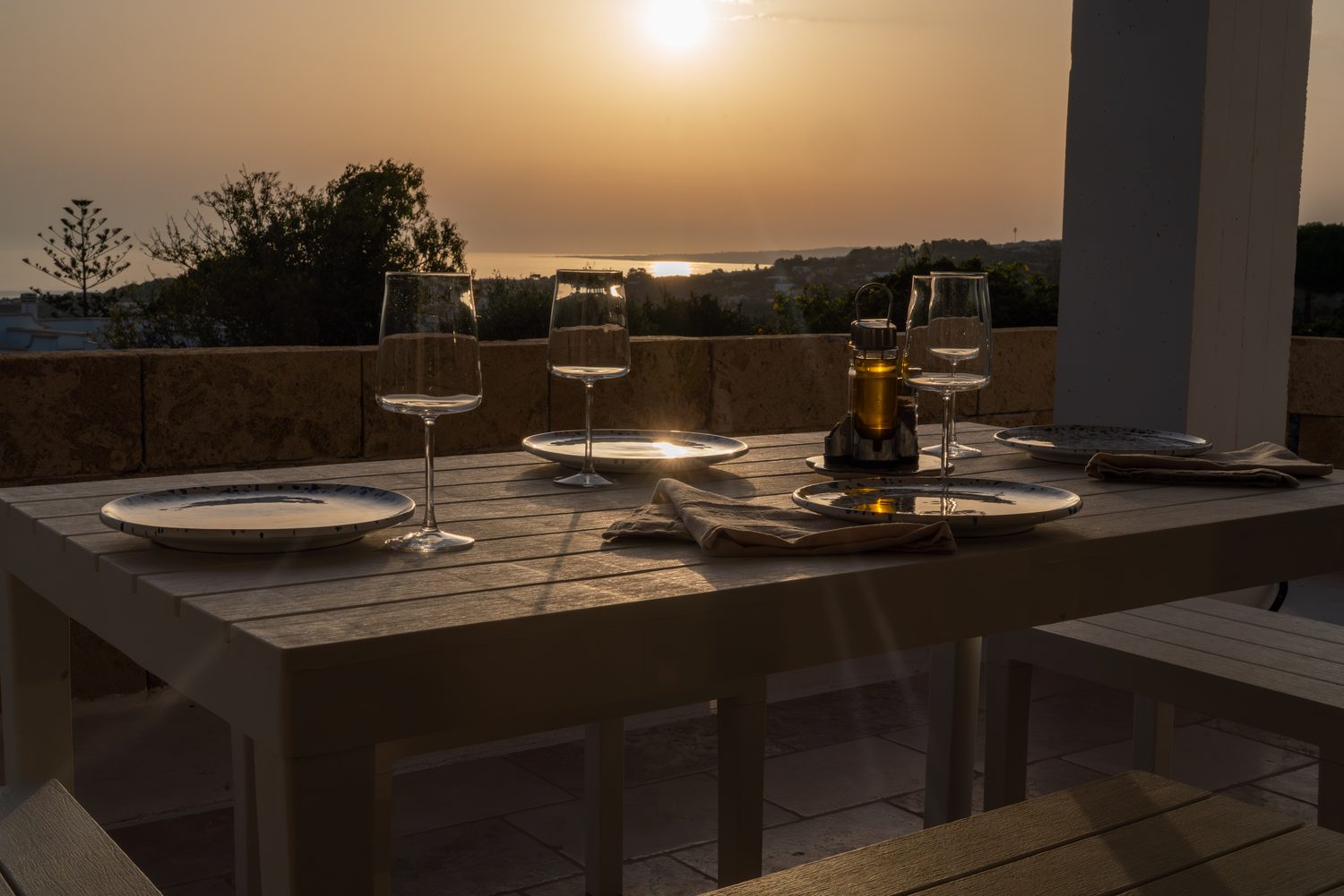Table dressée sur la terrasse face au soleil couchant sur la mer